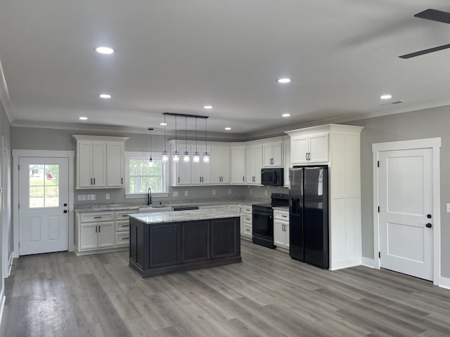 kitchen featuring black appliances, a wealth of natural light, pendant lighting, and white cabinets