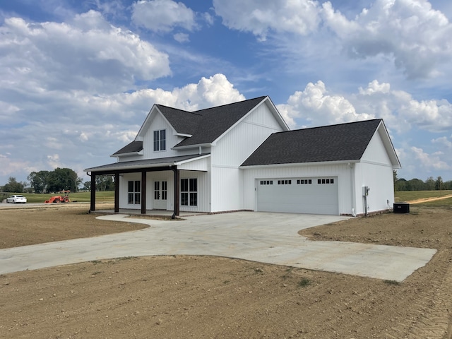 modern inspired farmhouse with cooling unit, a porch, and a garage