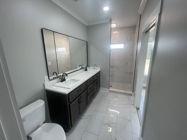 bathroom with vanity, toilet, and tiled shower