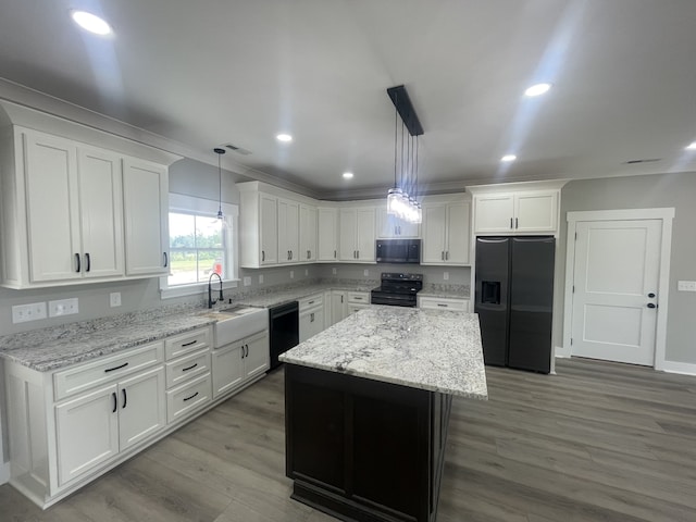 kitchen with black appliances, white cabinets, a center island, and decorative light fixtures