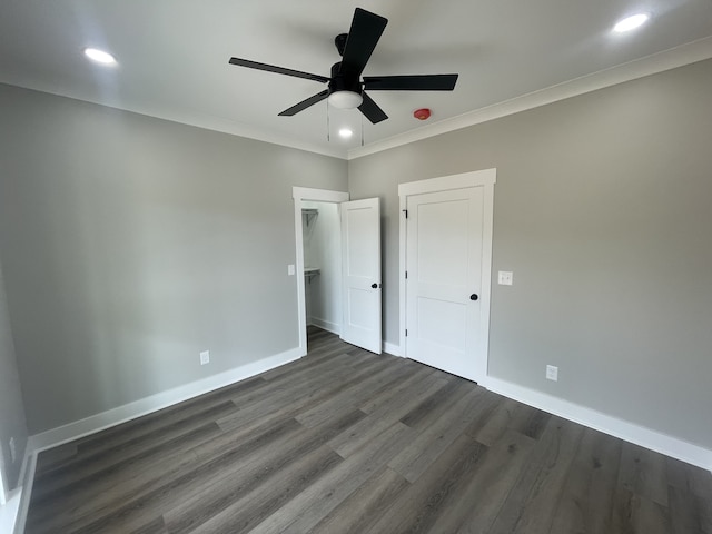 unfurnished bedroom with ceiling fan, dark hardwood / wood-style floors, and crown molding