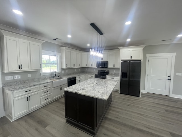 kitchen featuring white cabinets, black appliances, a center island, and decorative light fixtures