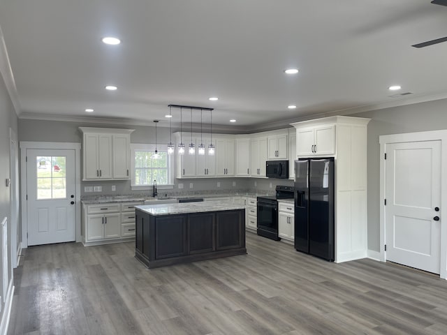 kitchen with sink, white cabinets, a kitchen island, black appliances, and decorative light fixtures