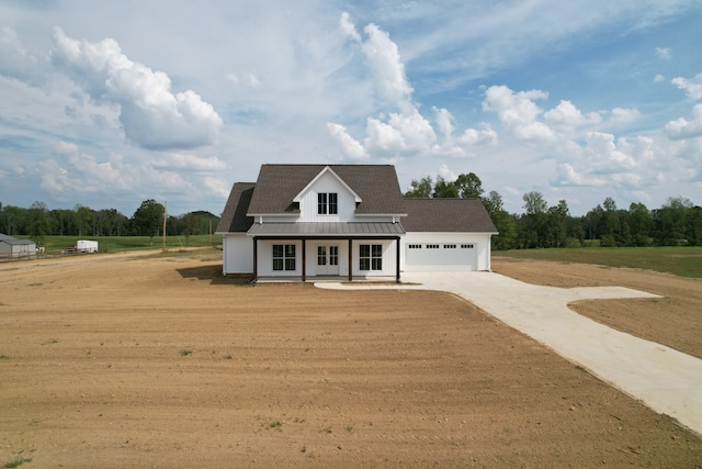 view of front of home with a front lawn, covered porch, and a garage