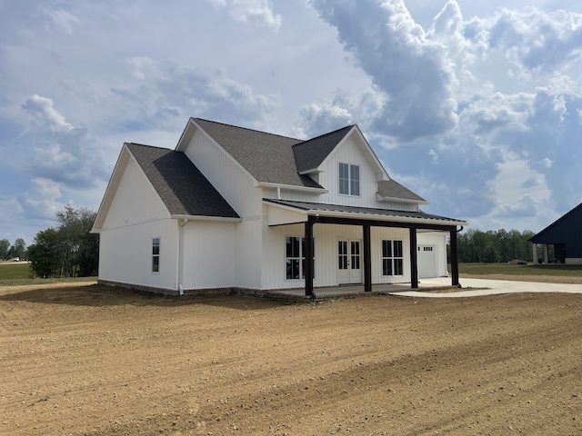 modern farmhouse style home featuring a front yard, a porch, and a garage