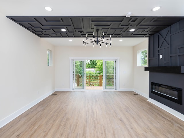 unfurnished living room featuring light wood-style floors, recessed lighting, a fireplace, and baseboards