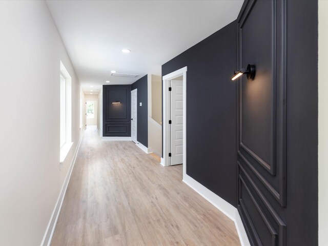 hall featuring light wood-style floors and baseboards