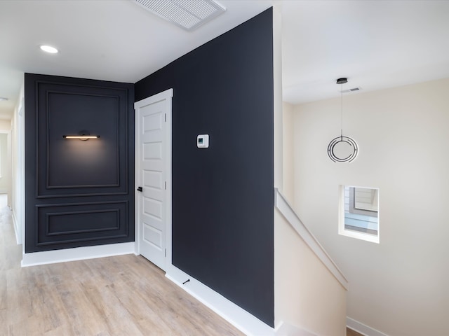 interior space featuring visible vents, light wood-style flooring, and baseboards