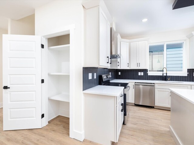 kitchen featuring light countertops, appliances with stainless steel finishes, a sink, and white cabinetry