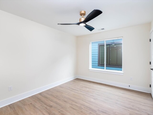 unfurnished room featuring light wood-style floors, visible vents, baseboards, and a ceiling fan