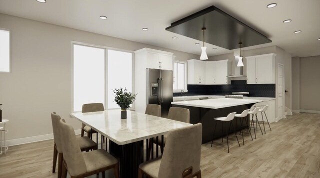 kitchen with stainless steel appliances, a kitchen island, white cabinets, light countertops, and decorative light fixtures