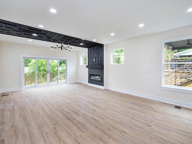 unfurnished living room featuring recessed lighting, a large fireplace, visible vents, and light wood finished floors