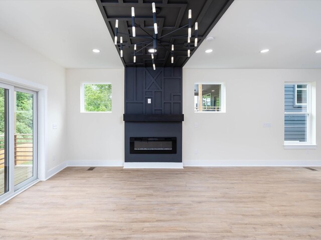 unfurnished living room with light wood finished floors, a fireplace, recessed lighting, and baseboards