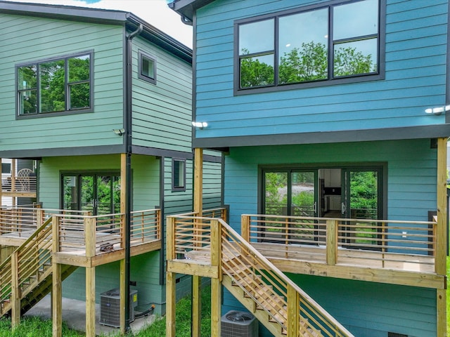 rear view of house featuring stairs and cooling unit