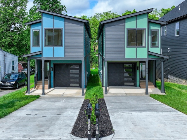 contemporary house featuring concrete driveway, an attached garage, and stucco siding