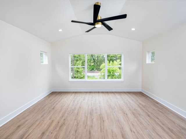 empty room with recessed lighting, vaulted ceiling, light wood-style flooring, and baseboards