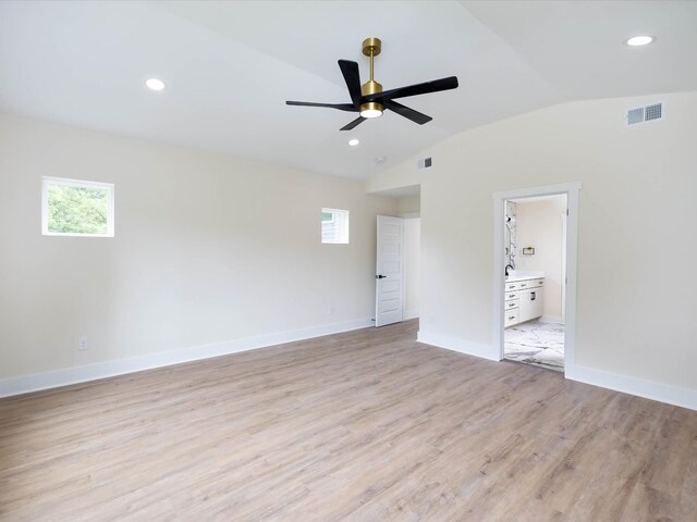 unfurnished room with lofted ceiling, a healthy amount of sunlight, visible vents, and light wood-style flooring