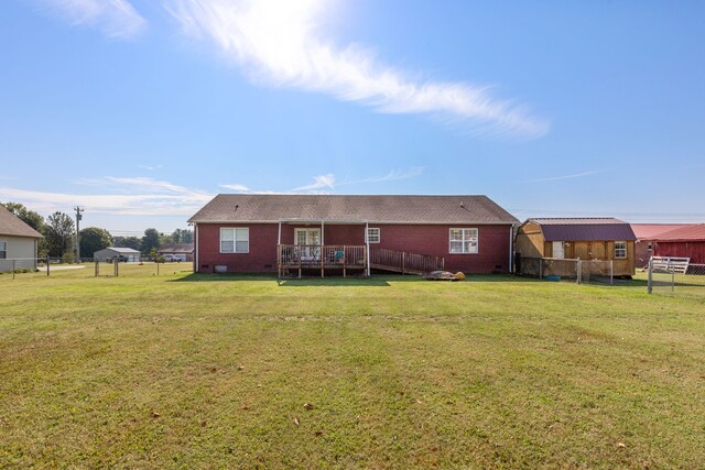 rear view of house featuring a yard and a deck