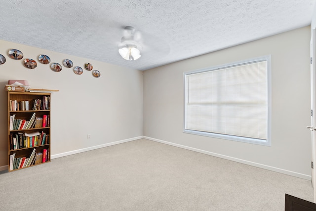 carpeted spare room with a textured ceiling