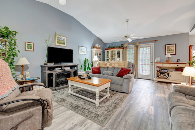 living room with ceiling fan, light hardwood / wood-style flooring, and lofted ceiling