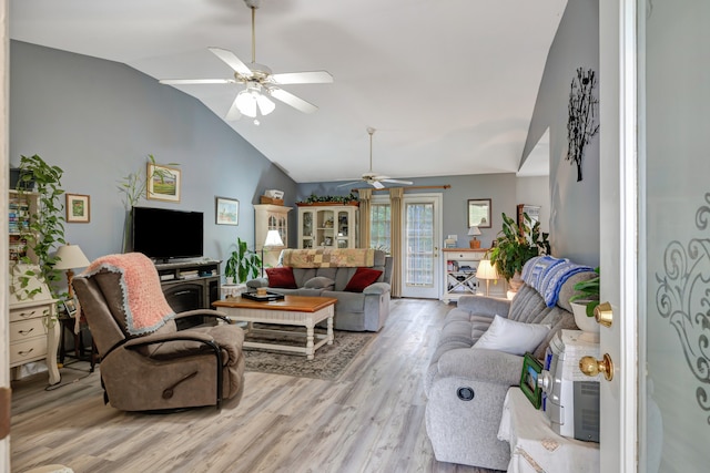 living room featuring ceiling fan, light hardwood / wood-style flooring, and vaulted ceiling