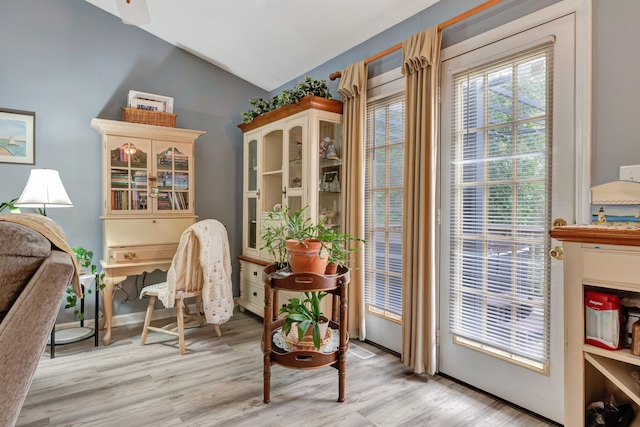 sitting room with ceiling fan, light hardwood / wood-style flooring, and vaulted ceiling