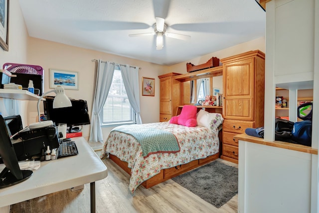 bedroom with ceiling fan, a textured ceiling, and light wood-type flooring