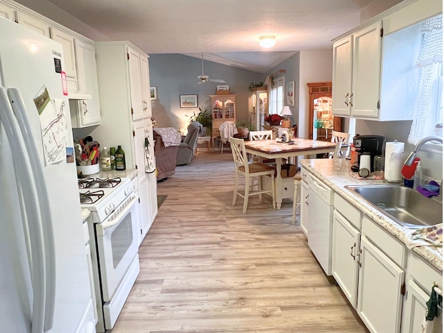 kitchen with light wood-type flooring, white appliances, vaulted ceiling, sink, and white cabinetry