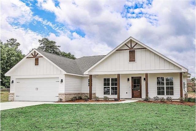 view of front of property featuring a front yard, a garage, and covered porch