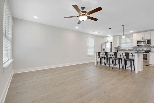 202 Summit St, Woodbury, TN 37190 - kitchen featuring stainless steel appliances, a kitchen breakfast bar, decorative backsplash, ceiling fan, and an island with sink