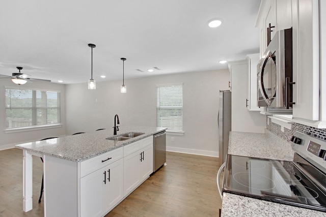 kitchen featuring a wealth of natural light, appliances with stainless steel finishes, decorative light fixtures, and sink