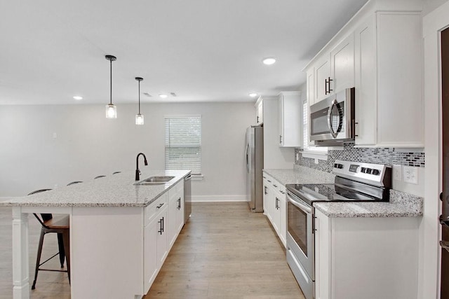 202 Summit St, Woodbury, TN 37190 - kitchen with white cabinets, a sink, baseboards, a center island with sink, and appliances with stainless steel finishes