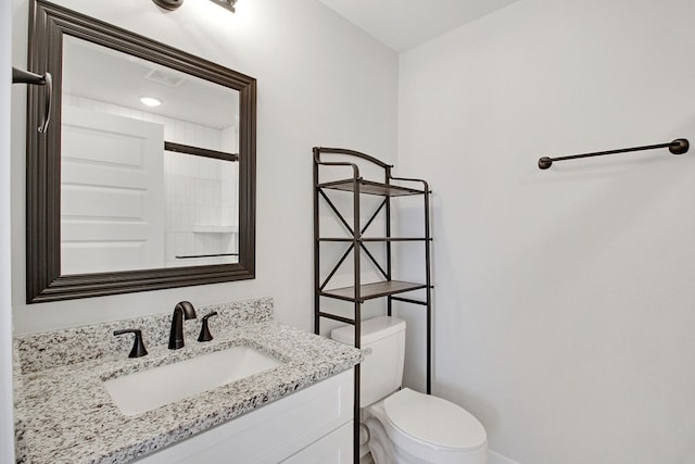 bathroom featuring walk in shower, vanity, and toilet