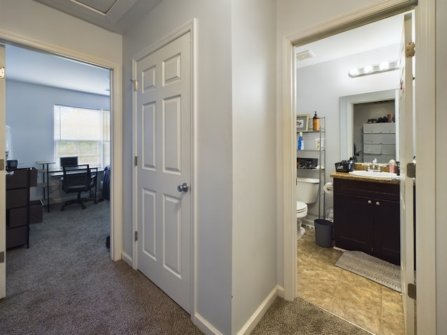 hallway featuring carpet and sink