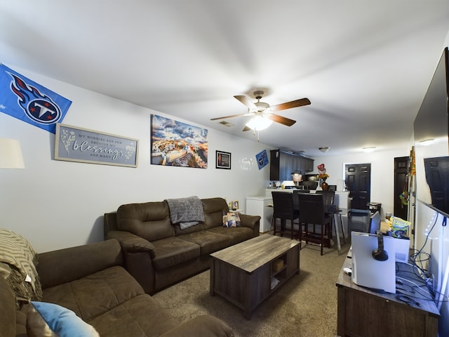 living room with ceiling fan and dark colored carpet