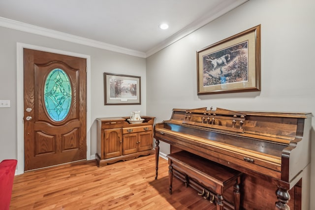 foyer entrance with light hardwood / wood-style flooring and ornamental molding