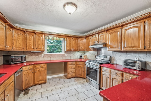 kitchen featuring a textured ceiling, backsplash, ornamental molding, and stainless steel appliances