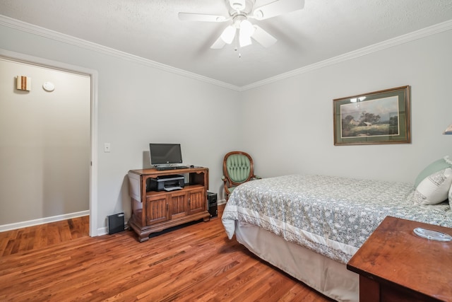 bedroom featuring a textured ceiling, wood-type flooring, crown molding, and ceiling fan