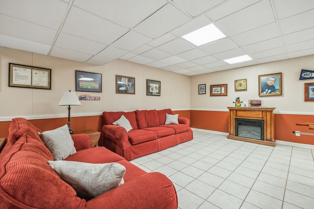 living room featuring a paneled ceiling and light tile patterned floors