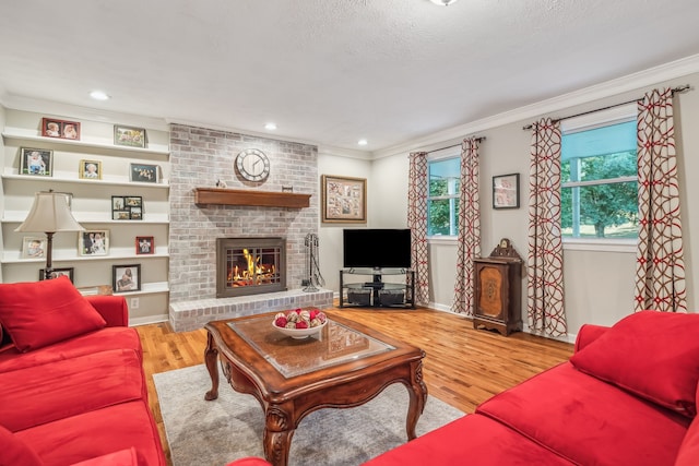 living room featuring ornamental molding, hardwood / wood-style floors, and a fireplace