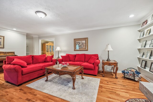 living room featuring wood-type flooring, a textured ceiling, and crown molding