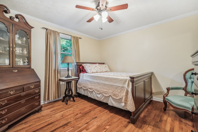 bedroom with a textured ceiling, crown molding, dark hardwood / wood-style flooring, and ceiling fan