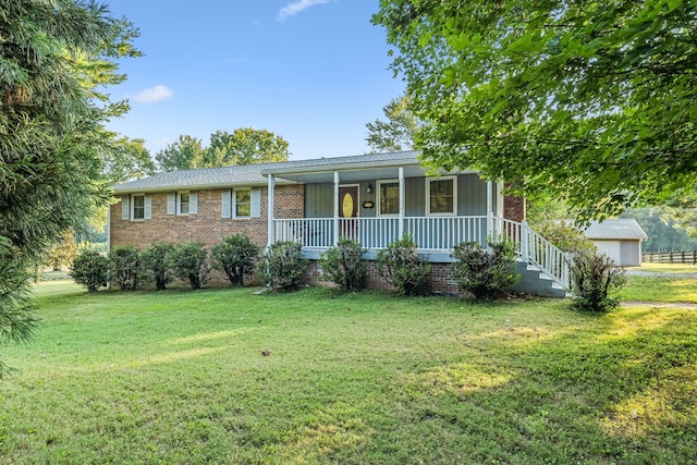 ranch-style home featuring an outdoor structure, a front lawn, and covered porch