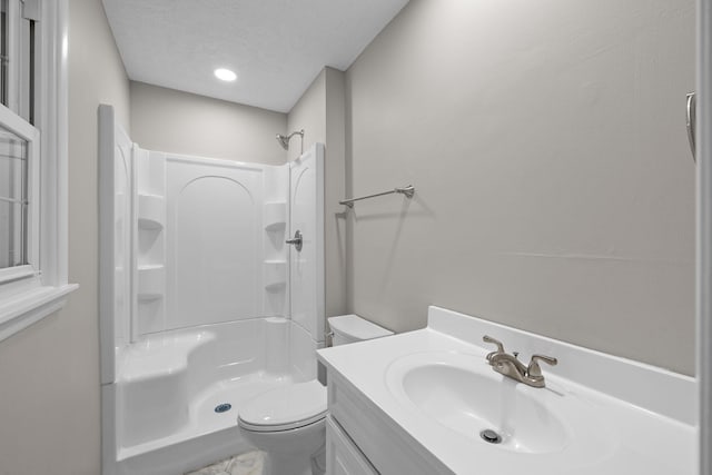 bathroom with toilet, vanity, a textured ceiling, and walk in shower