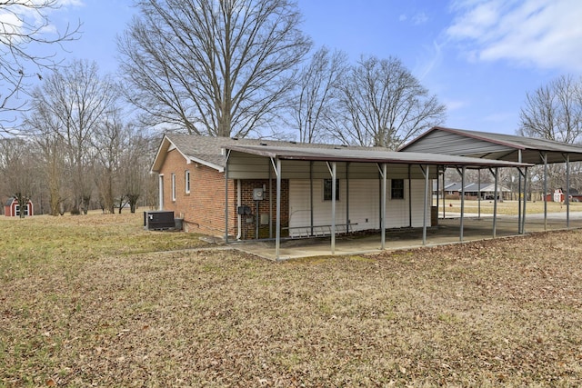 view of front of house featuring a carport, cooling unit, and a front lawn