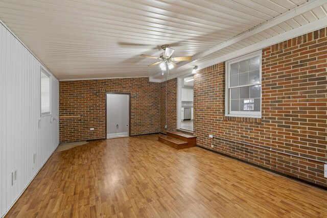 unfurnished living room featuring ceiling fan, brick wall, and light hardwood / wood-style floors