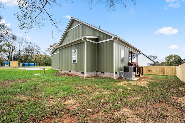 view of side of home featuring central AC unit and a lawn