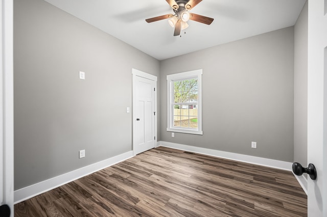 empty room featuring dark wood-type flooring and ceiling fan