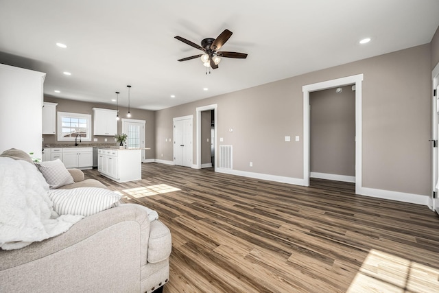 living room featuring sink, hardwood / wood-style floors, and ceiling fan