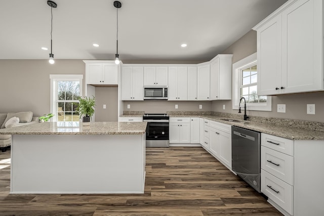 kitchen with sink, white cabinetry, a center island, appliances with stainless steel finishes, and pendant lighting